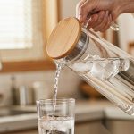BY-9160B-1 unbreakable PC stainless steel handle water pitcher (wood) - being poured by hand