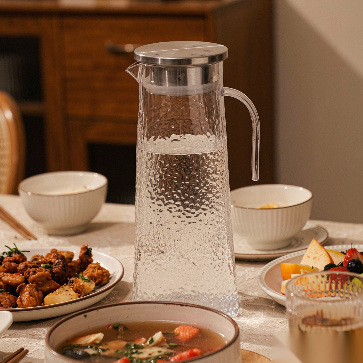 BY-9168 unbreakable PC stainless steel handle water pitcher (steel) - set on a dining table for dinner