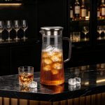 BY-9160C-1 unbreakable PC stainless steel handle water pitcher - on a black marble bar counter